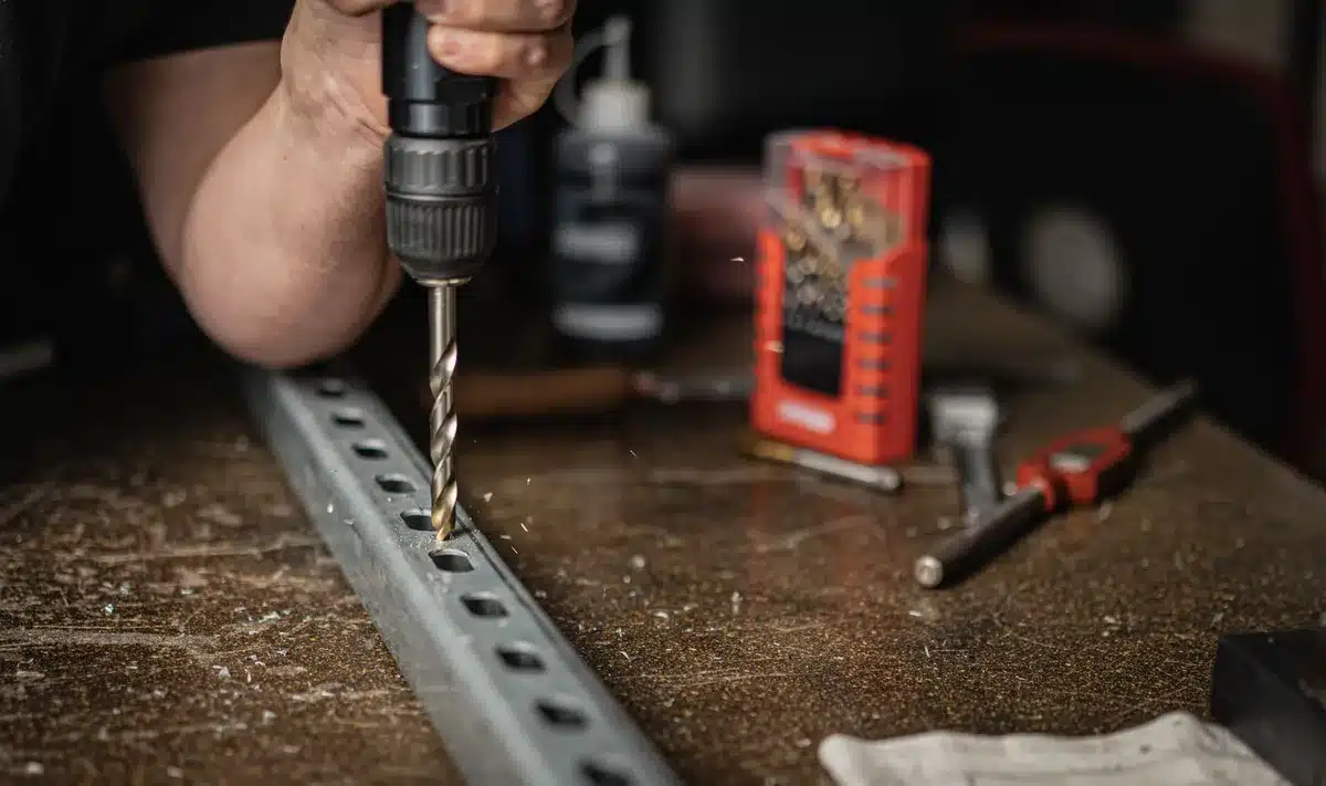 Outils de bricolage rassemblés pour transformer une passoire : perceuse, pince coupante, câbles électriques