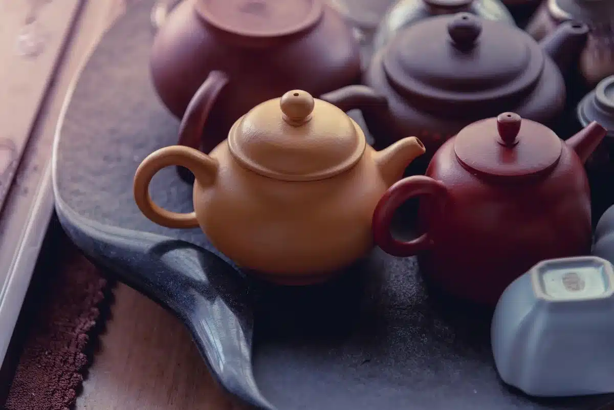 Bocal en verre contenant un purin de plantes en fermentation à côté de feuilles coupées