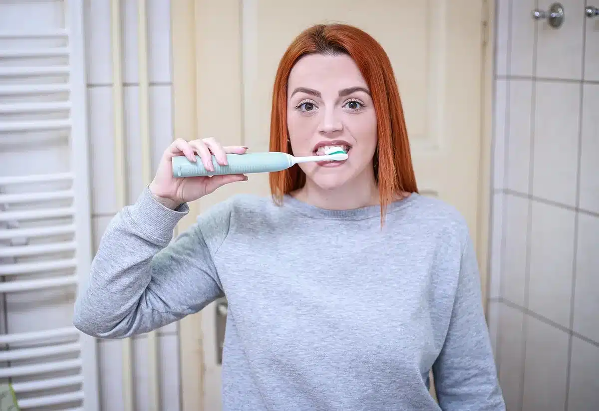 Brosse à dents appliquant du dentifrice sur la semelle blanche d'une sneaker