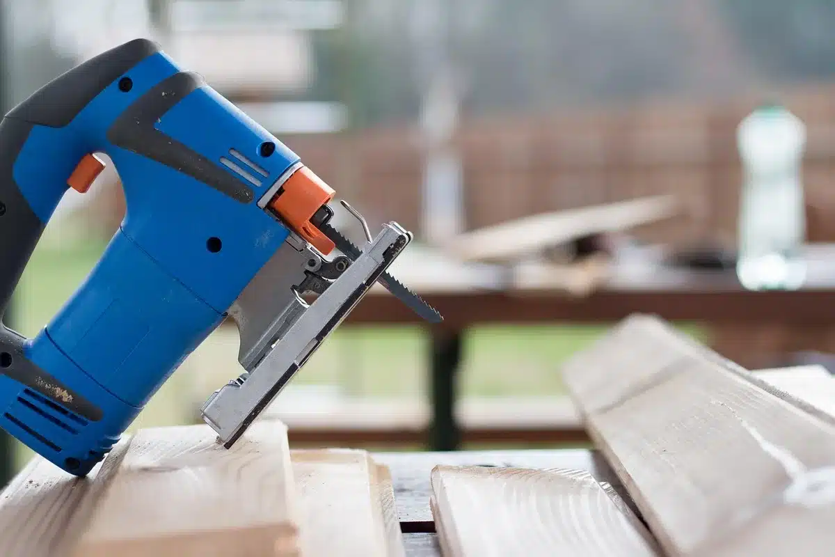 Outils de taille propres: sécateur, scie et gants posés sur une table de jardin
