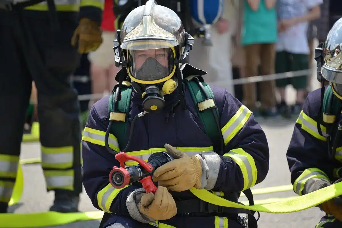 Technicien en combinaison de protection retirant un nid en hauteur