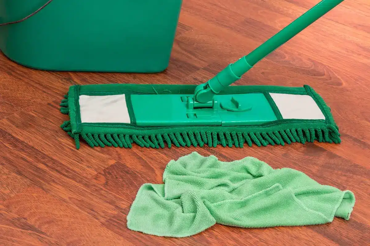 Main utilisant une raclette et chiffon microfibre sur une vitre